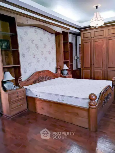 Elegant bedroom with wooden furniture and built-in wardrobe