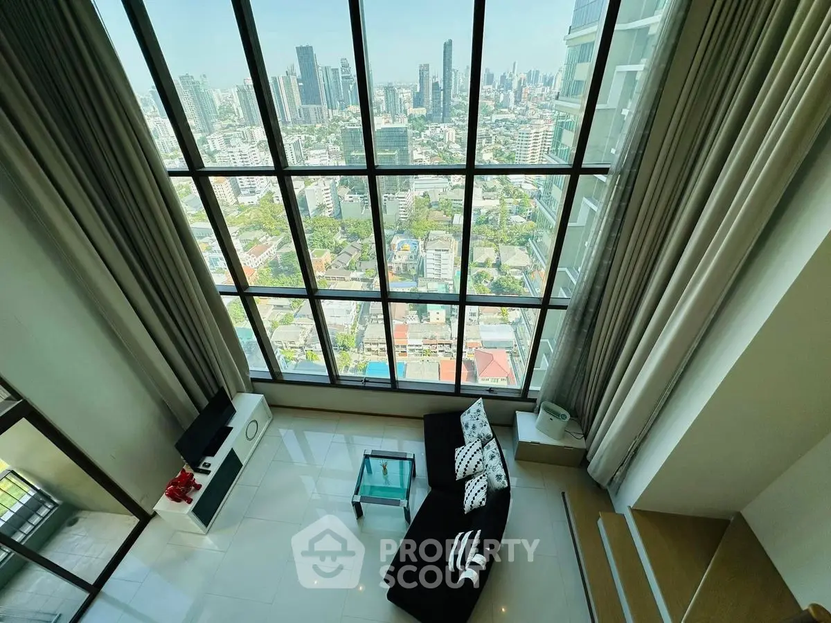 Stunning high-rise living room with floor-to-ceiling windows and breathtaking city view.