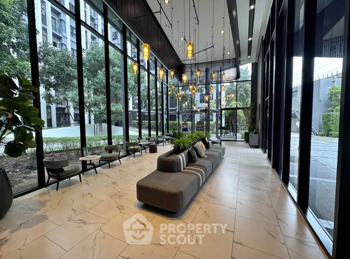 Luxurious modern lobby with floor-to-ceiling windows and elegant seating area in upscale building.