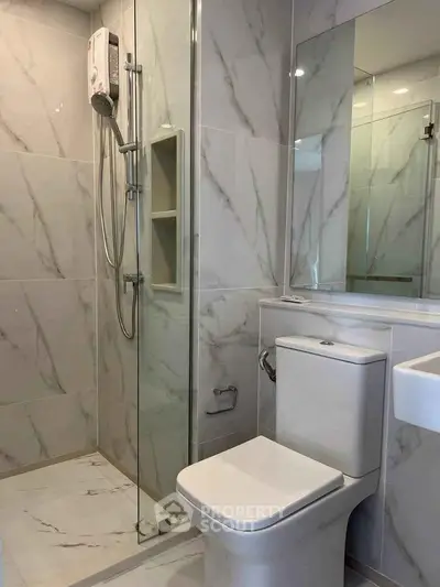 Modern bathroom with sleek marble tiles and glass shower enclosure