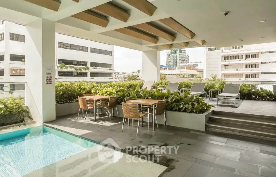 Luxurious rooftop pool area with modern seating and city views, perfect for relaxation and entertainment.