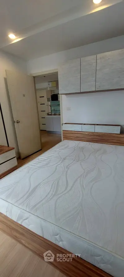 Modern bedroom with stylish wooden furniture and built-in storage solutions.
