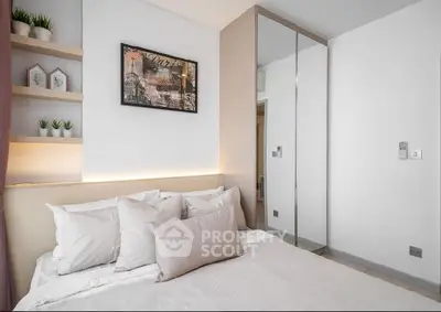 Modern bedroom with stylish decor and mirrored wardrobe in a cozy apartment.