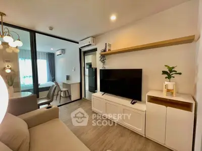 Modern living room with sleek design and open layout, featuring a cozy sofa and large TV.
