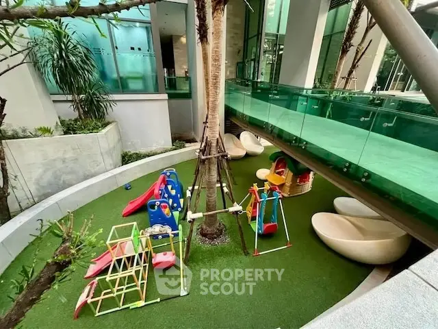 Modern residential building with vibrant outdoor playground and lush greenery.