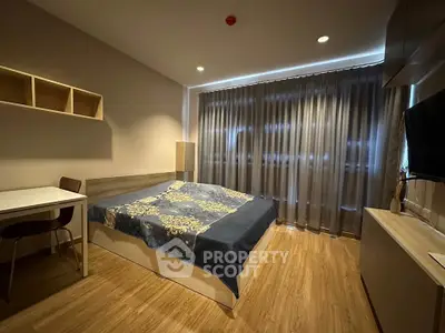 Cozy bedroom with modern decor and large window draped with curtains, featuring a comfortable bed and wooden flooring.