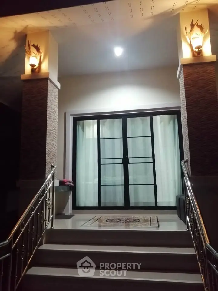 Elegant entrance with modern lighting and glass doors, perfect for welcoming guests.