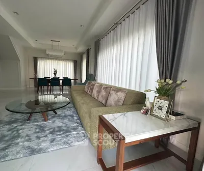Elegant living room with modern furniture and large windows, perfect for stylish living.