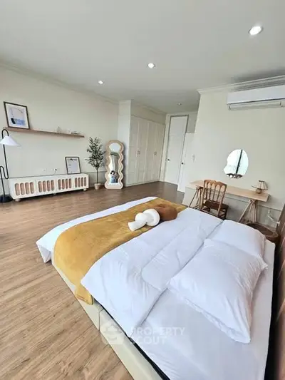 Spacious modern bedroom with elegant decor and wooden flooring