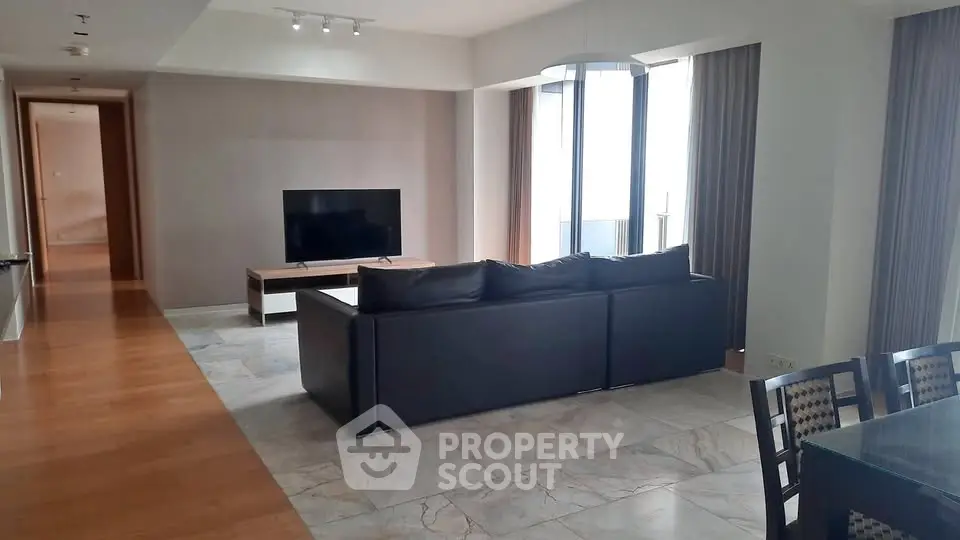 Spacious modern living room with sleek furniture and large windows offering natural light.