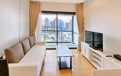 Spacious living room with city view, modern furniture, and large windows for natural light.