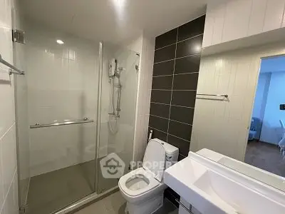Modern bathroom with glass shower and sleek fixtures in a contemporary apartment.