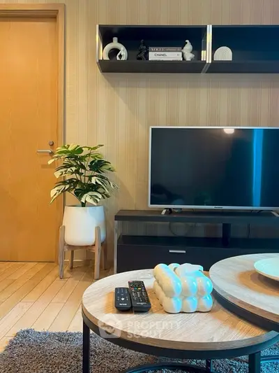 Stylish living room with modern decor, featuring a flat-screen TV and elegant coffee table.