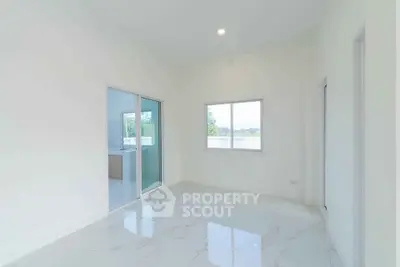 Spacious and bright room with large windows and glossy marble flooring, perfect for modern living.