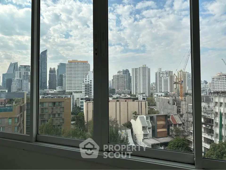 Stunning cityscape view from a modern apartment window, showcasing urban skyline.