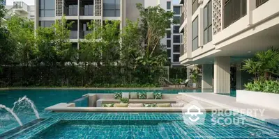 Luxurious modern apartment complex with stunning poolside seating area and lush greenery.