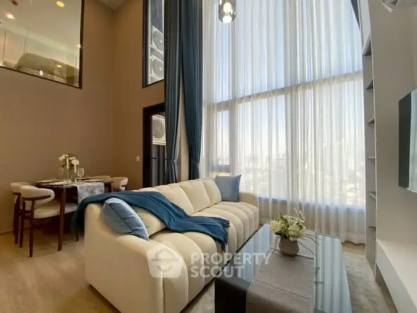 Luxurious high-ceiling living room with elegant decor and large windows