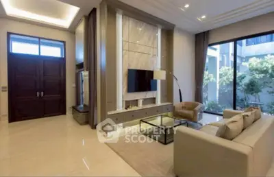 Luxurious living room with modern decor and large windows offering garden views.