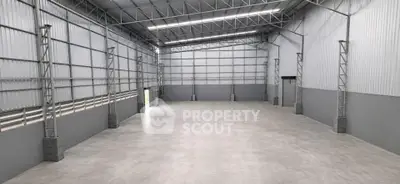 Spacious industrial warehouse with high ceilings and ample natural light.
