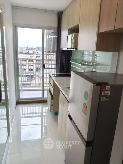 Modern kitchen with sleek cabinetry and city view from balcony.