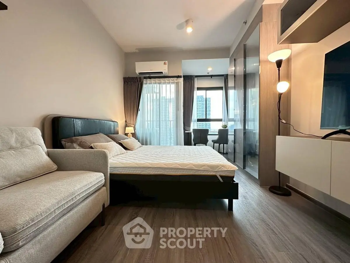 Modern bedroom with large window and city view, featuring stylish decor and cozy ambiance.