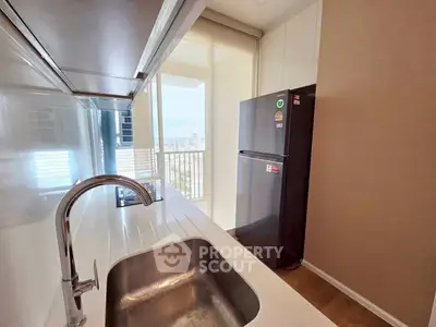 Modern kitchen with sleek design and stainless steel appliances in a high-rise apartment.