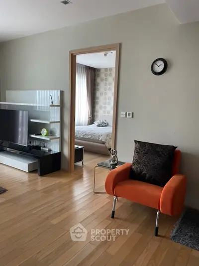 Modern living room with stylish decor and view into cozy bedroom