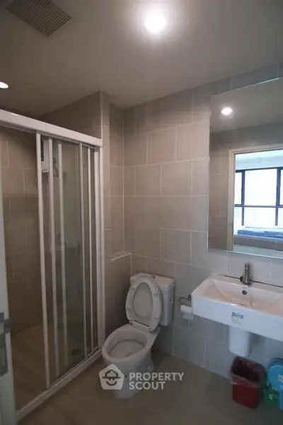 Modern bathroom with shower and sleek fixtures in contemporary apartment.