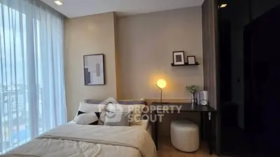 Modern bedroom with stylish decor and large window offering natural light.
