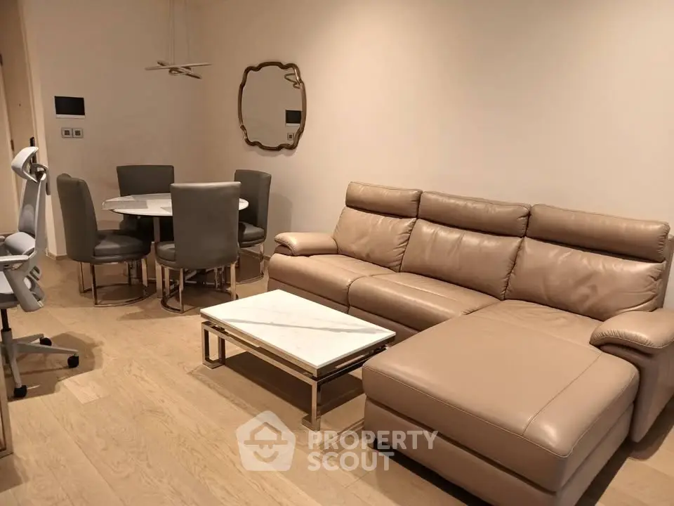 Modern living room with leather sofa and dining area in elegant apartment