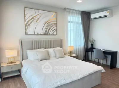 Modern bedroom with elegant decor, featuring a comfortable bed, stylish artwork, and a functional study desk.