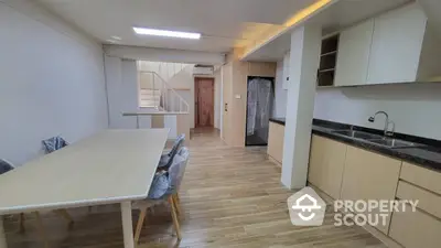 Modern kitchen and dining area with wooden flooring and sleek cabinetry