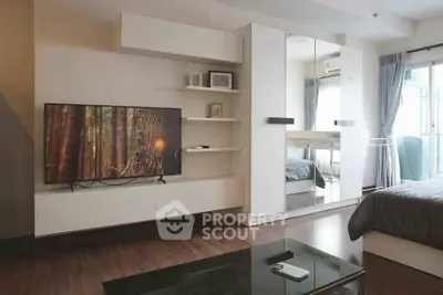 Modern bedroom with sleek furniture and large TV, featuring a stylish mirrored wardrobe.