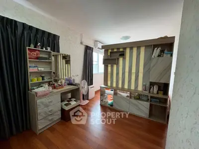 Spacious bedroom with elegant wooden flooring and modern storage solutions.