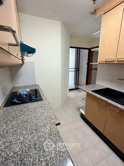 Modern kitchen with granite countertops and gas stove in sleek apartment