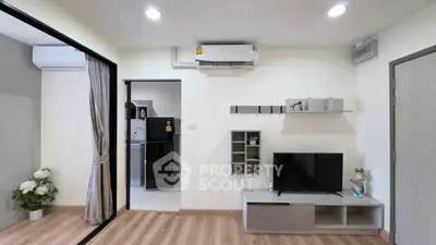 Modern living room with sleek decor and air conditioning, featuring a TV and stylish shelving.