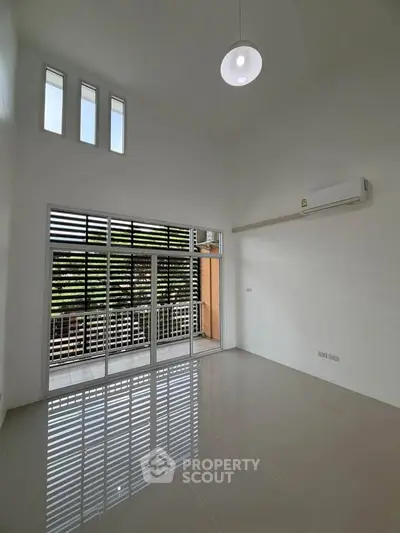Spacious living room with high ceiling and large windows for natural light