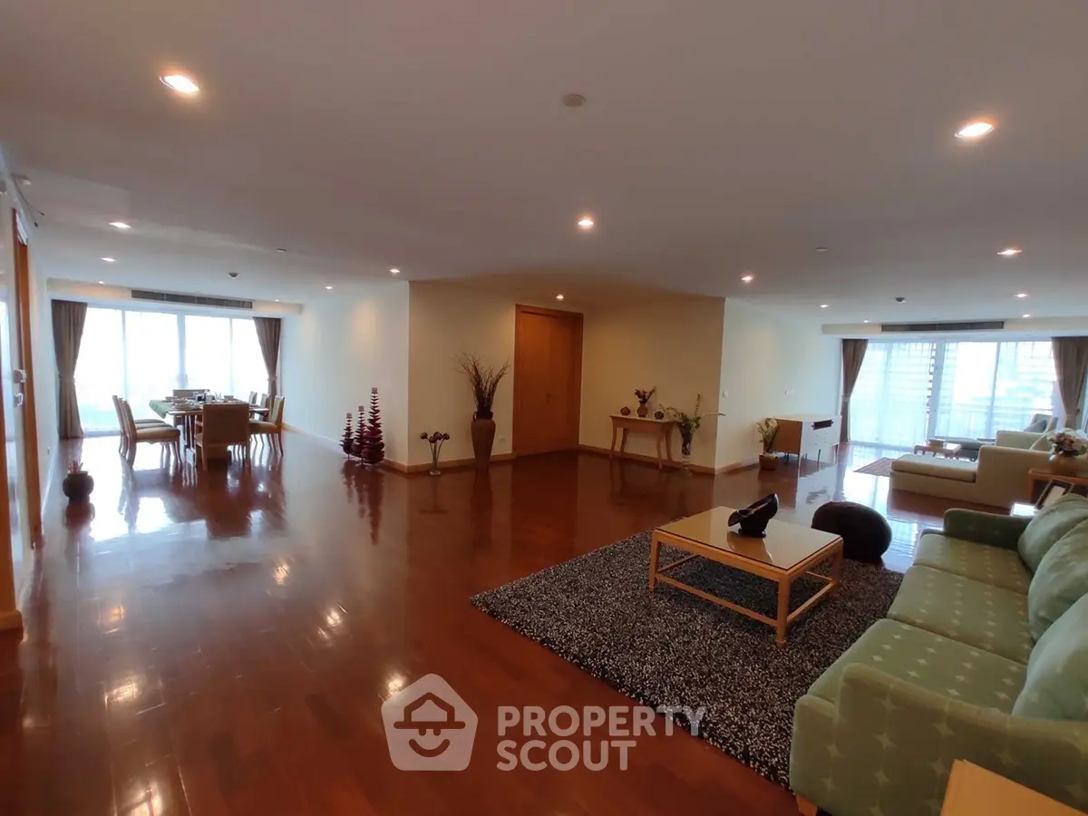 Spacious open-plan living and dining area with elegant hardwood floors and modern furnishings.