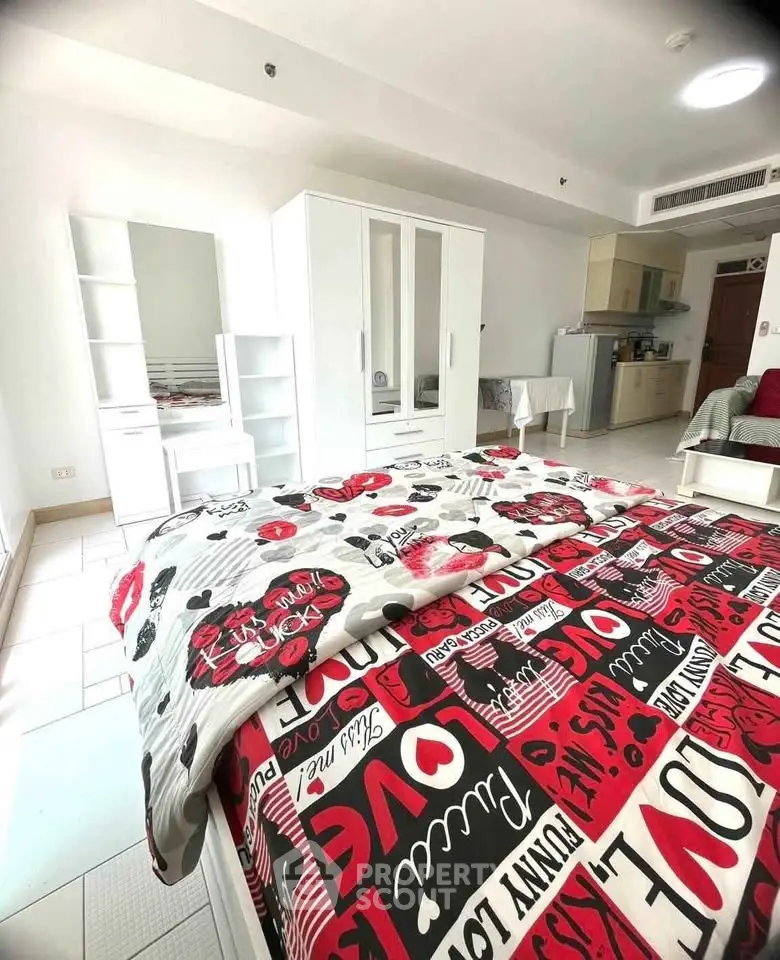 Spacious bedroom with modern decor and open kitchen layout in a stylish apartment.