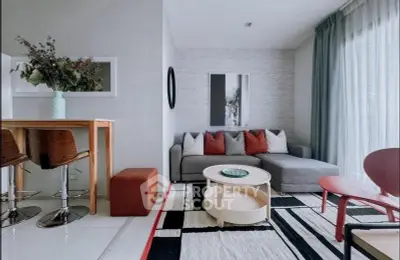 Stylish modern living room with cozy gray sofa, chic decor, and vibrant accents in a contemporary apartment.