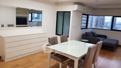 Spacious modern living room with city view, featuring sleek furniture and large windows.