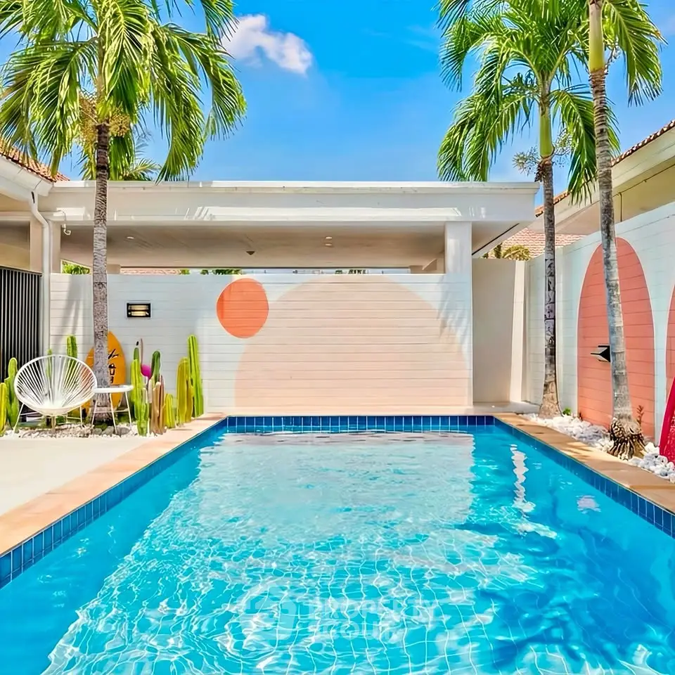 Stunning tropical pool area with vibrant mural and palm trees, perfect for relaxation and entertainment.
