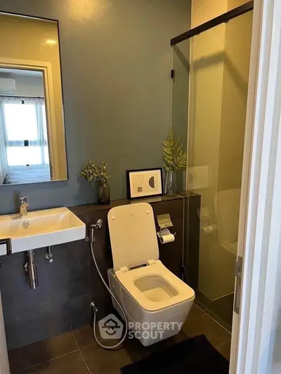 Modern bathroom with sleek design, featuring a glass shower and contemporary fixtures.