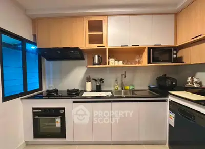 Modern kitchen with sleek cabinetry, gas stove, and built-in oven in a stylish apartment.