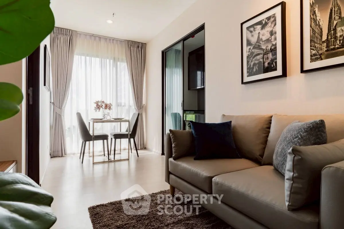 Modern living room with elegant decor and cozy seating area, leading to a bright dining space with natural light.