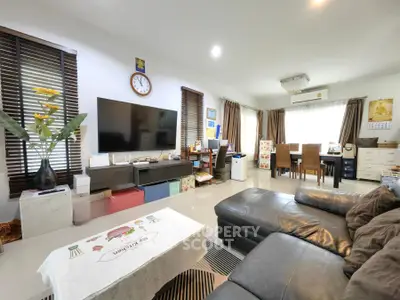 Spacious living room with modern decor and large TV, perfect for family gatherings.