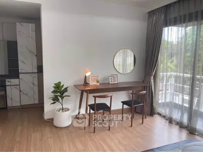 Stylish modern living room with elegant decor and large window overlooking greenery, perfect for relaxation.