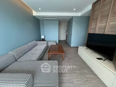 Modern living room with stylish furniture and large TV in a contemporary apartment.