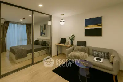 Modern bedroom with stylish decor and cozy seating area, featuring a large mirror and elegant lighting.