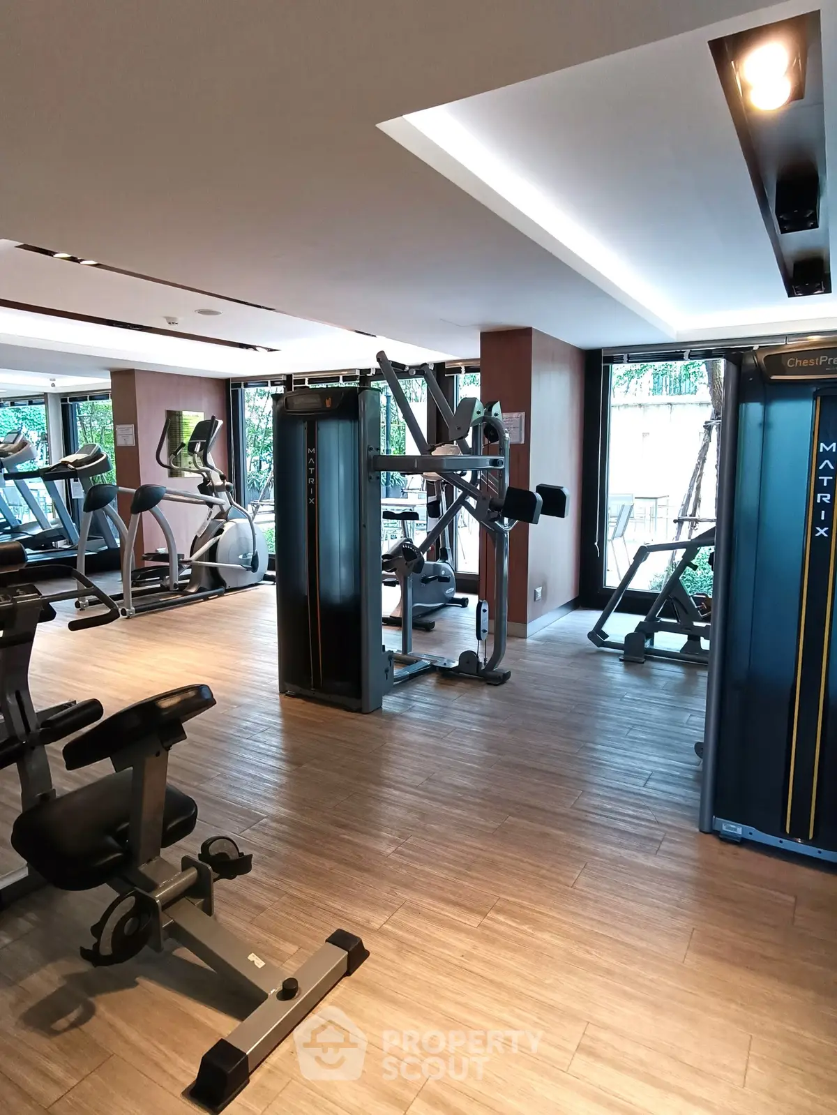 Modern gym with state-of-the-art fitness equipment and large windows for natural light.